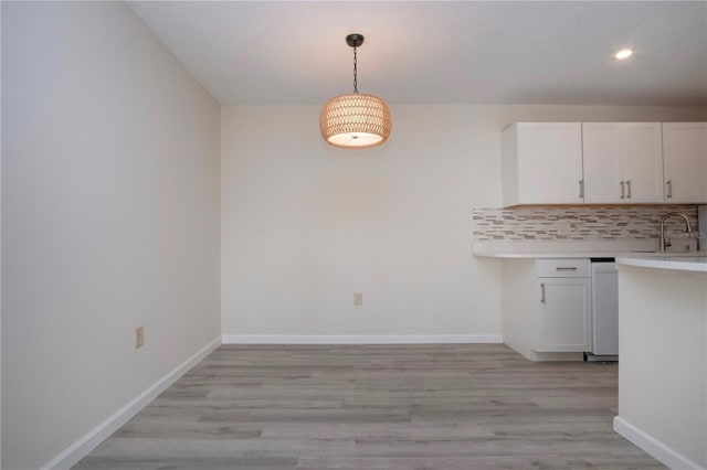 unfurnished dining area with sink and light wood-type flooring