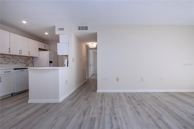 kitchen with light hardwood / wood-style flooring, sink, white cabinetry, white appliances, and decorative backsplash