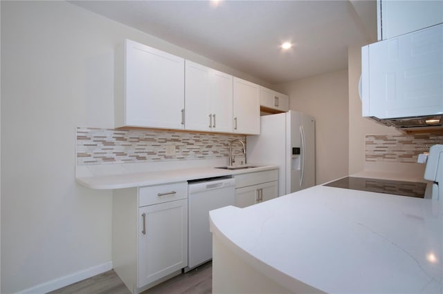 kitchen with backsplash, white appliances, white cabinets, and light wood-type flooring