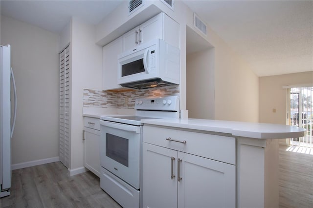 kitchen with white appliances, white cabinets, light hardwood / wood-style floors, backsplash, and kitchen peninsula