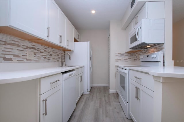 kitchen with white appliances, white cabinets, sink, backsplash, and light wood-type flooring