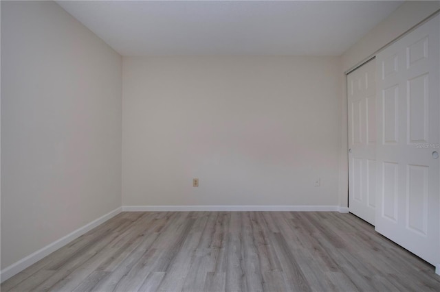 unfurnished bedroom with light hardwood / wood-style flooring and a closet