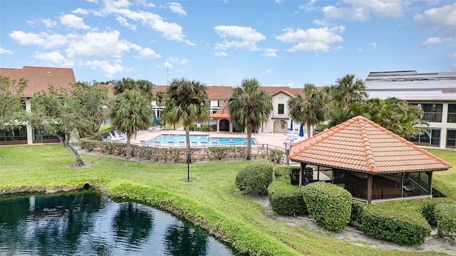 exterior space featuring a gazebo, a lawn, and a water view