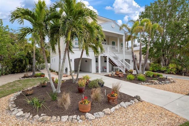 raised beach house featuring a garage and covered porch