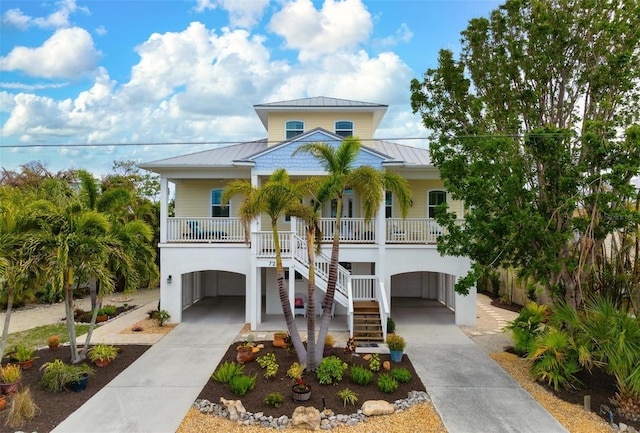 raised beach house featuring a carport and covered porch