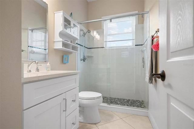 bathroom with vanity, a shower with shower door, tile patterned floors, and toilet