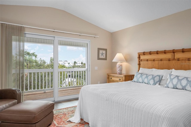 bedroom featuring hardwood / wood-style flooring, lofted ceiling, and access to outside