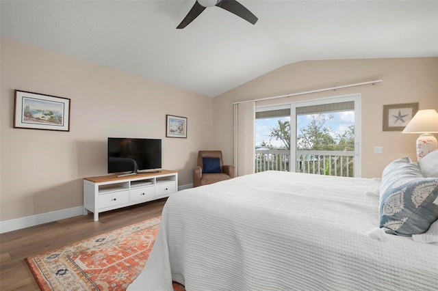 bedroom featuring vaulted ceiling, dark hardwood / wood-style floors, access to exterior, and ceiling fan