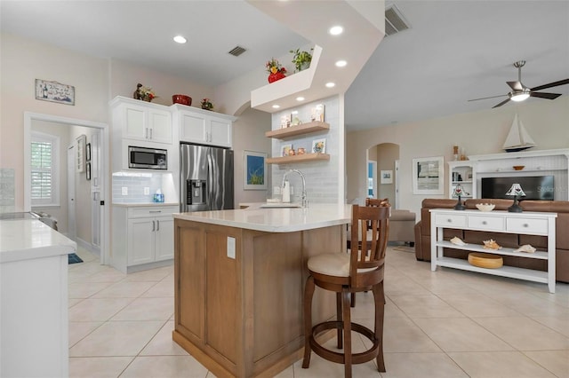 kitchen featuring white cabinetry, sink, a breakfast bar area, light tile patterned floors, and stainless steel appliances