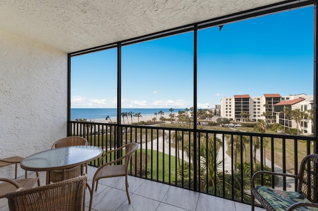 sunroom featuring a water view