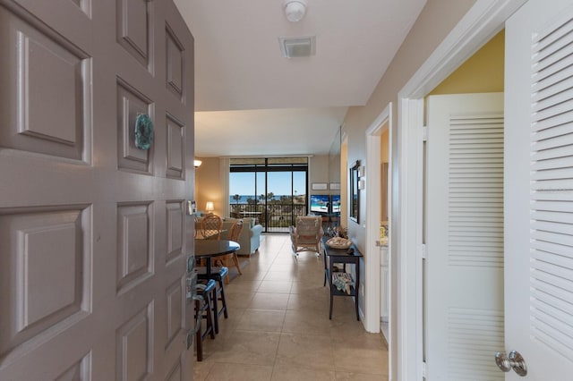 foyer entrance featuring expansive windows and light tile patterned floors