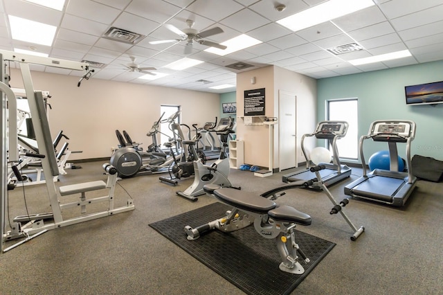 gym with ceiling fan and a drop ceiling