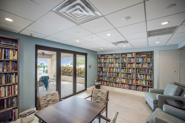 office area with built in shelves, french doors, and light hardwood / wood-style flooring