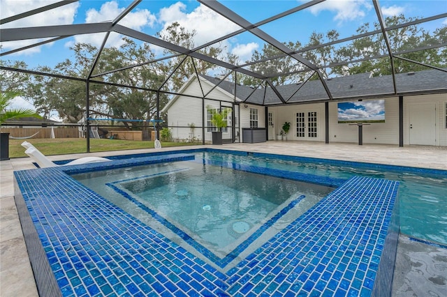 view of pool featuring a patio, glass enclosure, and an in ground hot tub