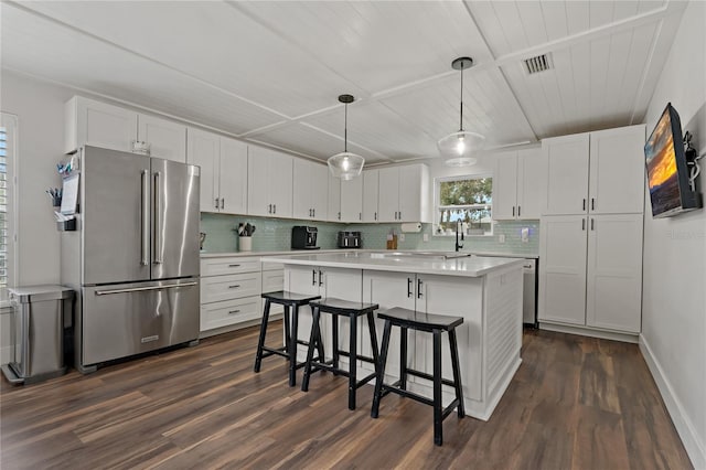 kitchen with white cabinets, decorative light fixtures, a kitchen island, and high end refrigerator