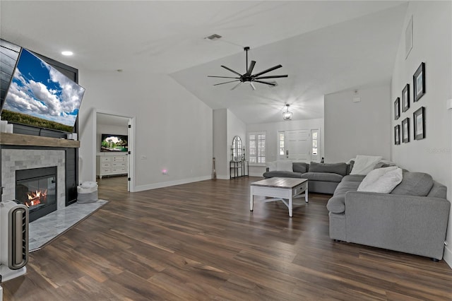 living room with lofted ceiling, a tiled fireplace, ceiling fan, and dark hardwood / wood-style floors