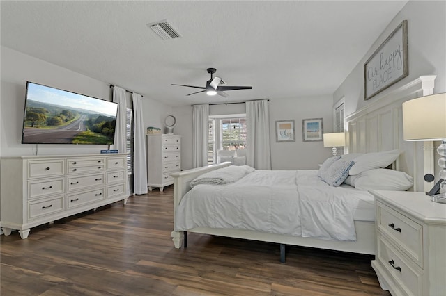 bedroom with ceiling fan, a textured ceiling, and dark hardwood / wood-style floors