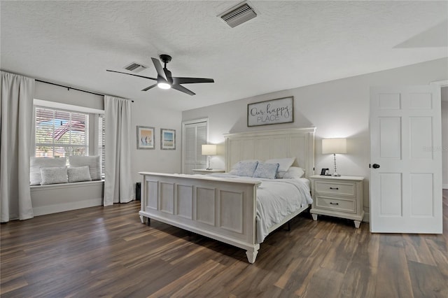 bedroom featuring a textured ceiling, ceiling fan, and dark hardwood / wood-style floors