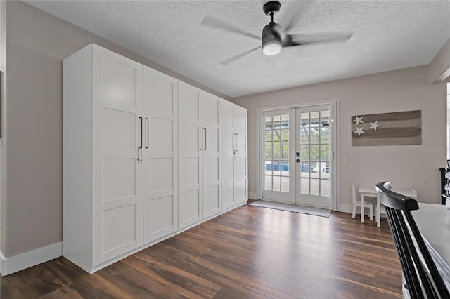 interior space with ceiling fan, dark hardwood / wood-style flooring, french doors, and a textured ceiling