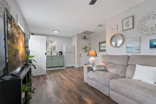 living room with ceiling fan and dark wood-type flooring