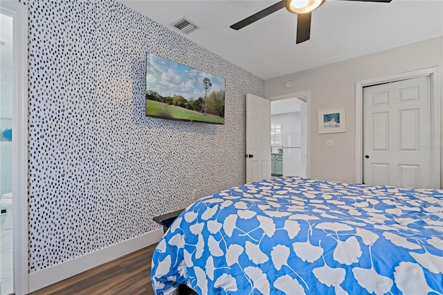 bedroom with ceiling fan, dark hardwood / wood-style flooring, and connected bathroom