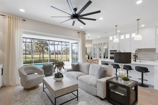 living room with ceiling fan and light hardwood / wood-style flooring