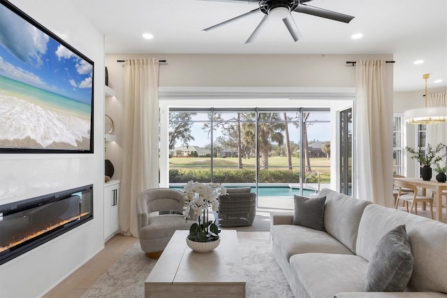 living room with ceiling fan and light hardwood / wood-style flooring