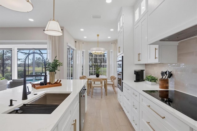 kitchen featuring decorative light fixtures, sink, white cabinets, and stainless steel appliances