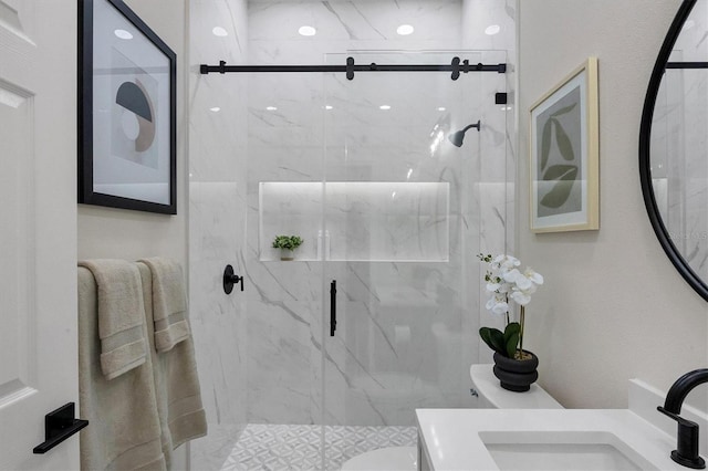 bathroom featuring toilet, a shower with door, and vanity