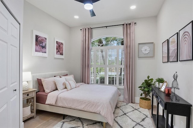 bedroom with a closet, multiple windows, light hardwood / wood-style flooring, and ceiling fan