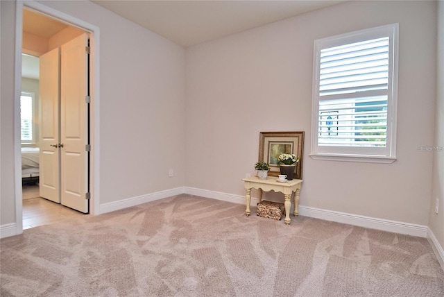 unfurnished room featuring light colored carpet