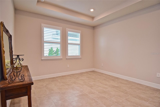 unfurnished room featuring a raised ceiling