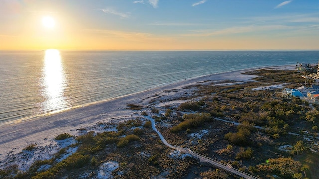 aerial view at dusk with a water view and a view of the beach