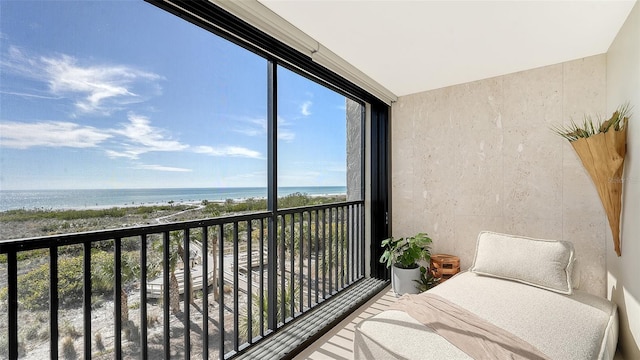 balcony featuring a beach view and a water view