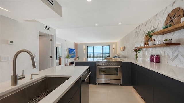 kitchen featuring light tile patterned flooring, stainless steel appliances, sink, and decorative backsplash