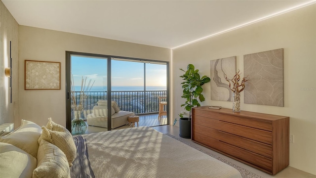 bedroom featuring a water view and access to exterior