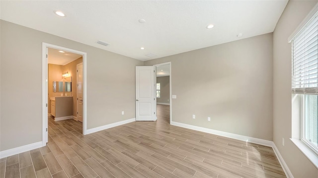 spare room featuring light hardwood / wood-style floors and plenty of natural light