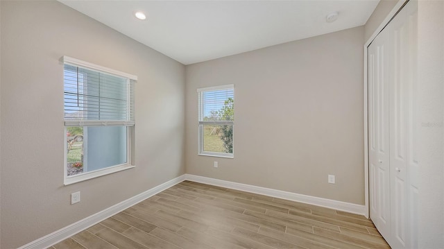 unfurnished bedroom with a closet and light hardwood / wood-style floors