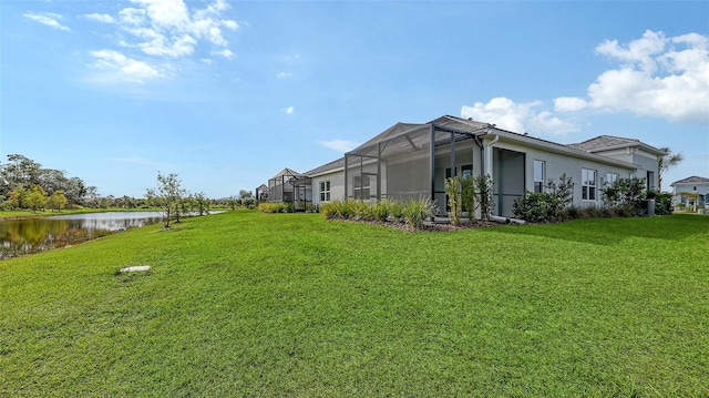 view of yard with a water view and glass enclosure