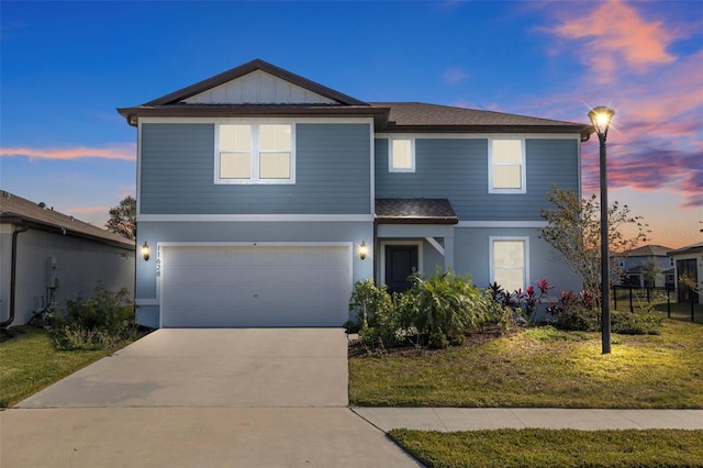 front facade featuring a garage and a yard