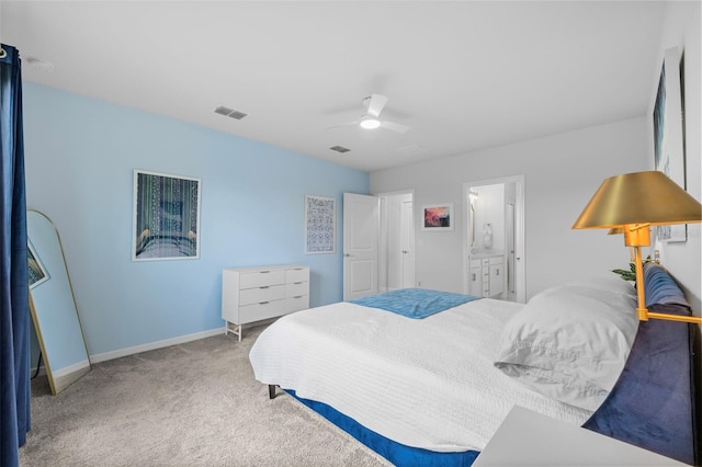 carpeted bedroom with ceiling fan and ensuite bath