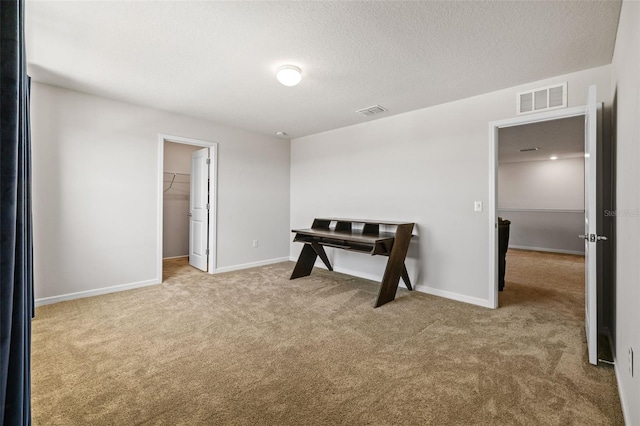 interior space featuring a textured ceiling and light carpet