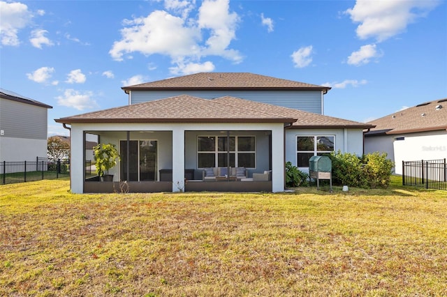 back of property with a yard and a sunroom