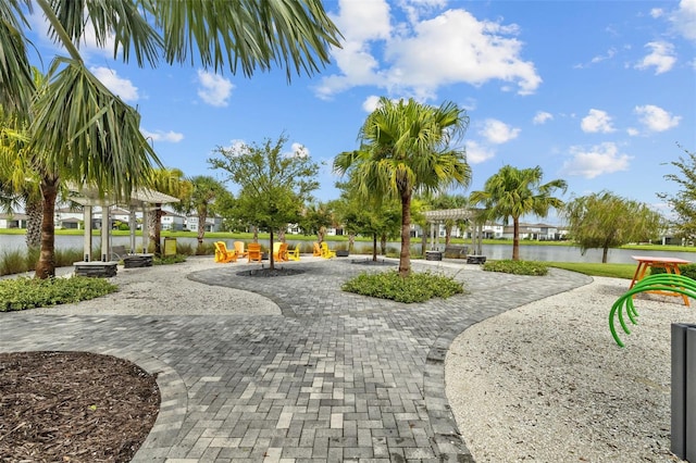 surrounding community with a water view and a patio area