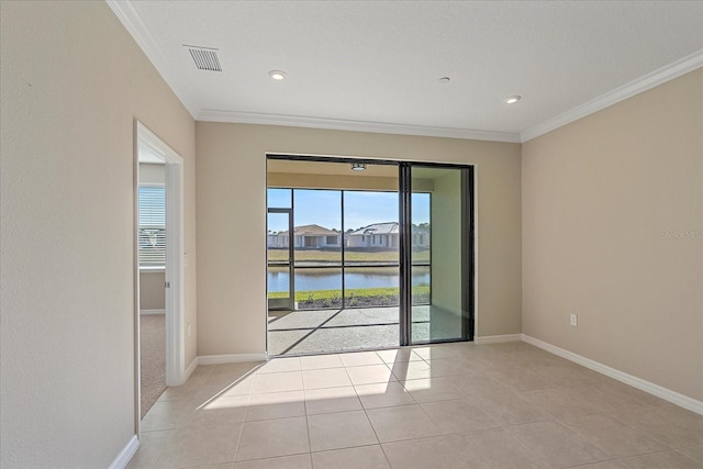 empty room featuring a water view, ornamental molding, and light tile patterned floors