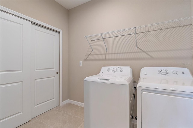 washroom with light tile patterned floors and washing machine and clothes dryer