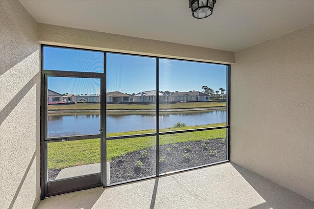 unfurnished sunroom with a healthy amount of sunlight and a water view