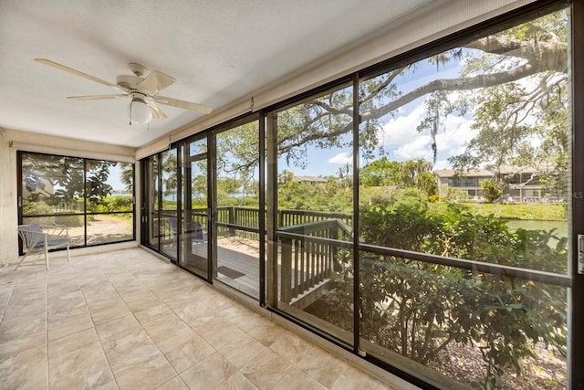 unfurnished sunroom featuring ceiling fan