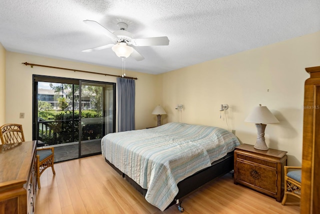 bedroom with ceiling fan, light hardwood / wood-style flooring, a textured ceiling, and access to exterior