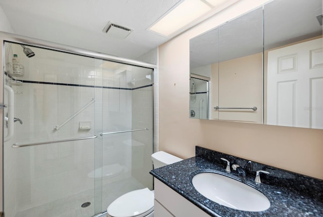 bathroom with toilet, an enclosed shower, and vanity